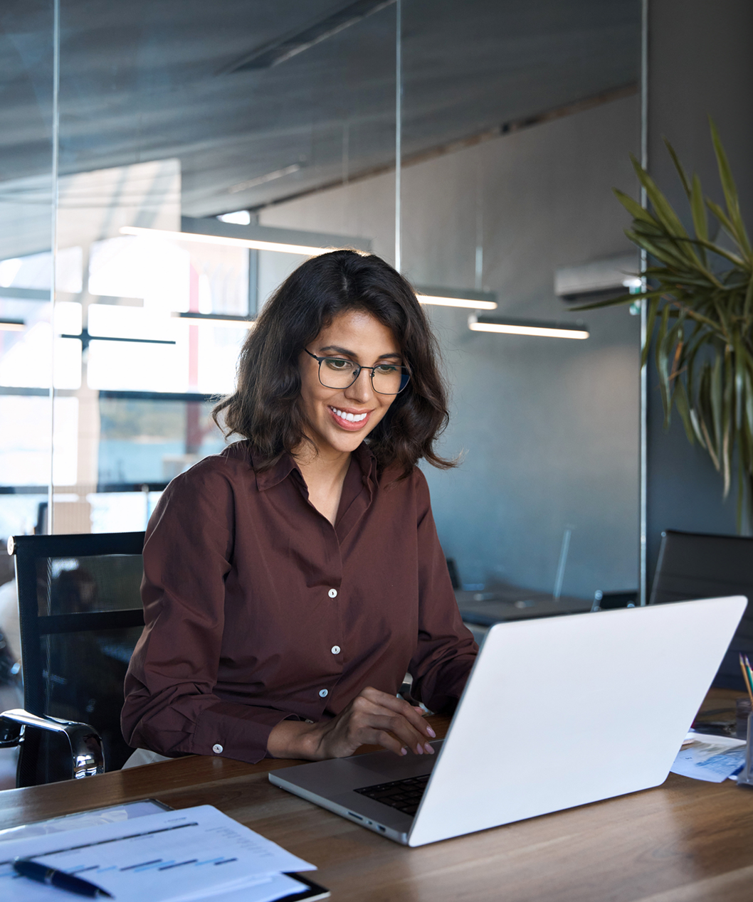 Woman smiling while working on a laptop.